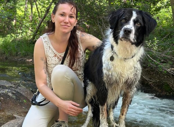 photo d'un humain et de son chien en balade prêt d'un rivière